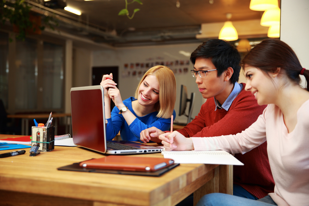 Three people working together on a computer